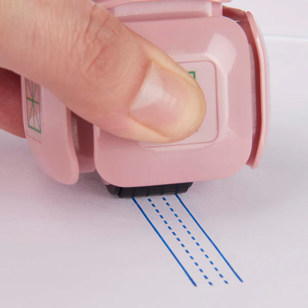 LegiLiner LegiCube Self-Inking Teacher Stamp - Math and Handwriting Lines Multi-Roller Stamp stamping dotted lines within blue lines in white sheet from AskSAMIE