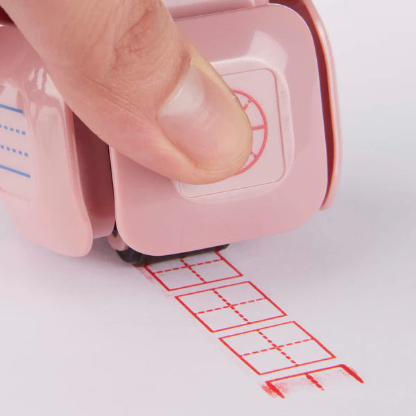 LegiLiner LegiCube Self-Inking Teacher Stamp - Math and Handwriting Lines Multi-Roller Stamp stamping red box of square quarters in white sheet from AskSAMIE