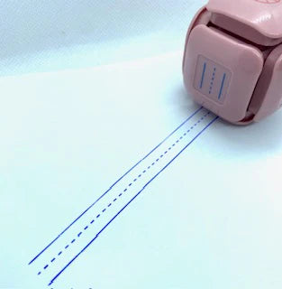 LegiLiner LegiCube Self-Inking Teacher Stamp - Math and Handwriting Lines Multi-Roller Stamp stamping blue lines dotted in white sheet from AskSAMIE