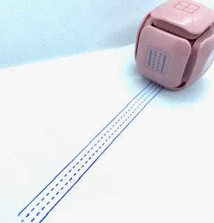 LegiLiner LegiCube Self-Inking Teacher Stamp - Math and Handwriting Lines Multi-Roller Stamp stamping blue lines in white sheet from AskSAMIE
