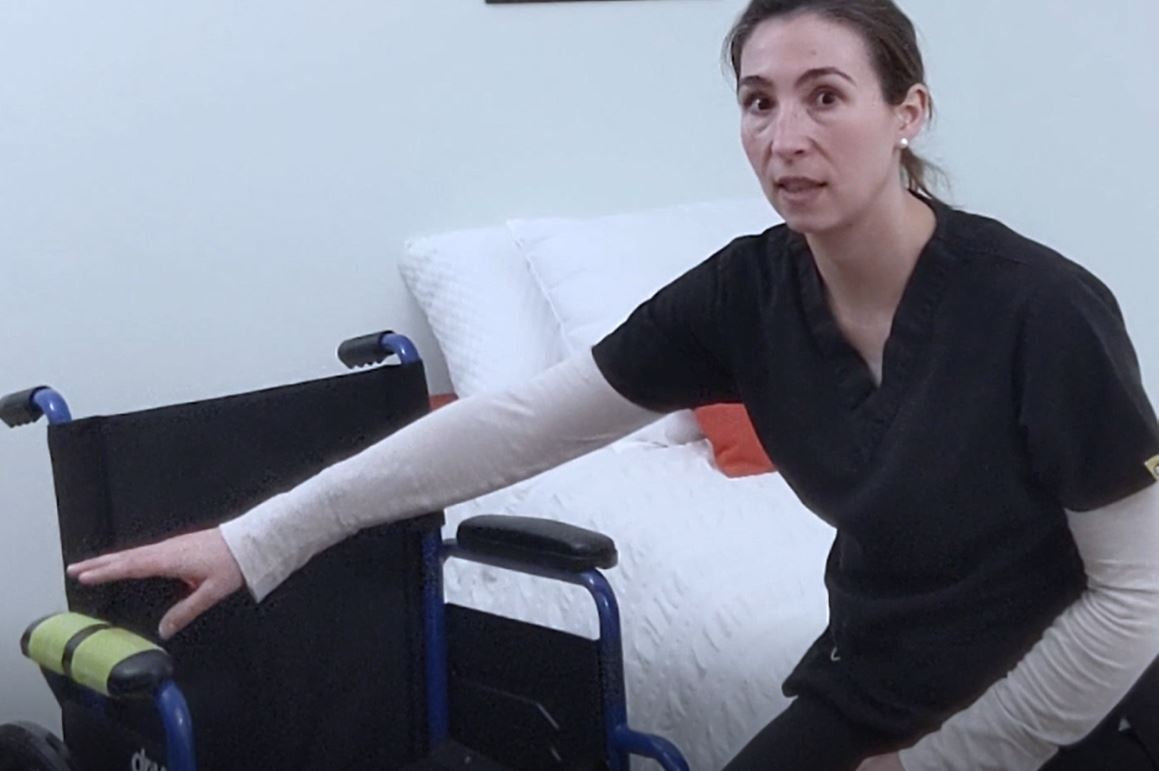woman sitting on bed next to wheelchair