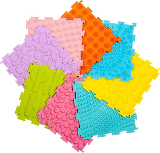 Eight interlocking foam sensory tiles fanned out, each with a different raised texture including shells, bumps, cactus, leaves, and dots, in soft pastel colors