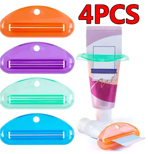 Four toothpaste squeezers in orange, purple, green, and blue shown with one fitted to a toothpaste tube, sold as a 4 pack.