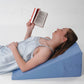 Woman reading lying on bed wedge