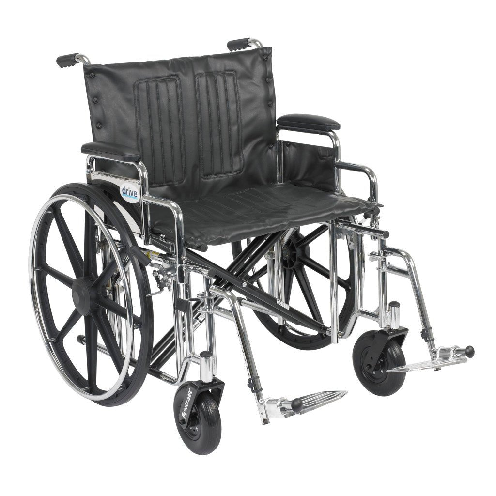 Bariatric manual wheelchair with a wide black seat, detachable padded desk arms, and swing-away footrests, rated to 500 lb.