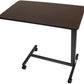 Angled view of the rolling overbed table showing the 15 by 30 inch tabletop, single steel column, and swivel casters that slide under a bed or recliner.