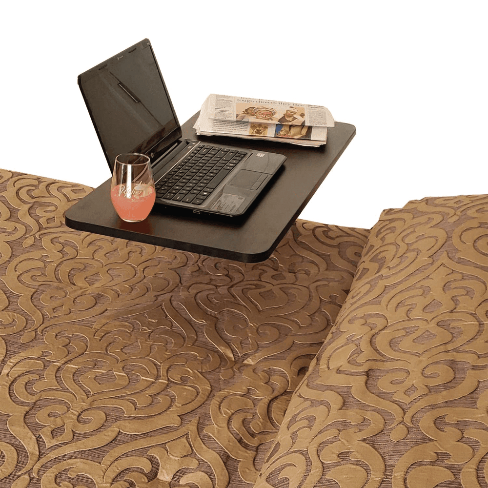 Overbed table positioned over a bed holding a laptop, newspaper, and drink so a person on bed rest can work and eat without getting up.