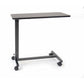 Roscoe non-tilt overbed table on wheels with a walnut wood-grain tabletop and steel H-base, a height-adjustable hospital bedside table for eating and reading in bed.