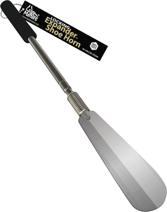 FootMatters locking expander shoe horn shown full length on a white background, with a telescoping stainless steel shaft, a flexible spring neck, and a wide polished horn.