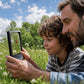 Parent and child looking at a ladybug through an ocularX rectangular lighted magnifier outdoors.