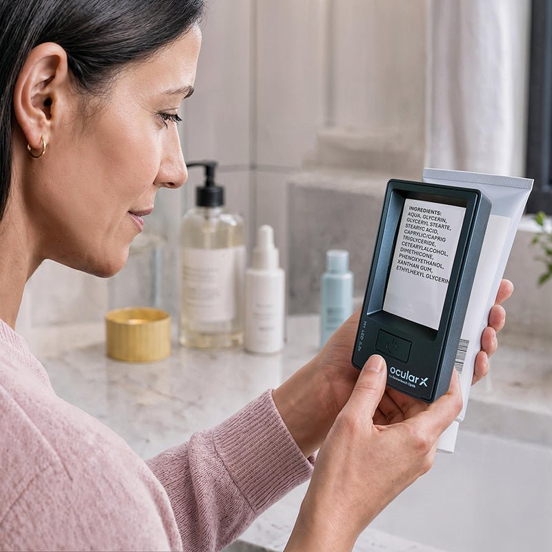 Woman using an ocularX lighted rectangular magnifier to read the small print on a bathroom product label.