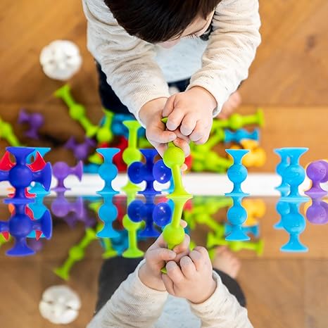 child playing with Squigz Suction Toys sticking them at mirror from AskSAMIE

