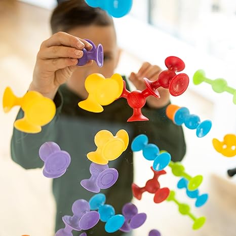 Child playing with Squigz Suction Toys sticking them on the mirror from AskSAMIE
