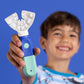 A smiling boy holding out the SymplBrush Jr. adaptive toothbrush for kids ages 5 to 12.