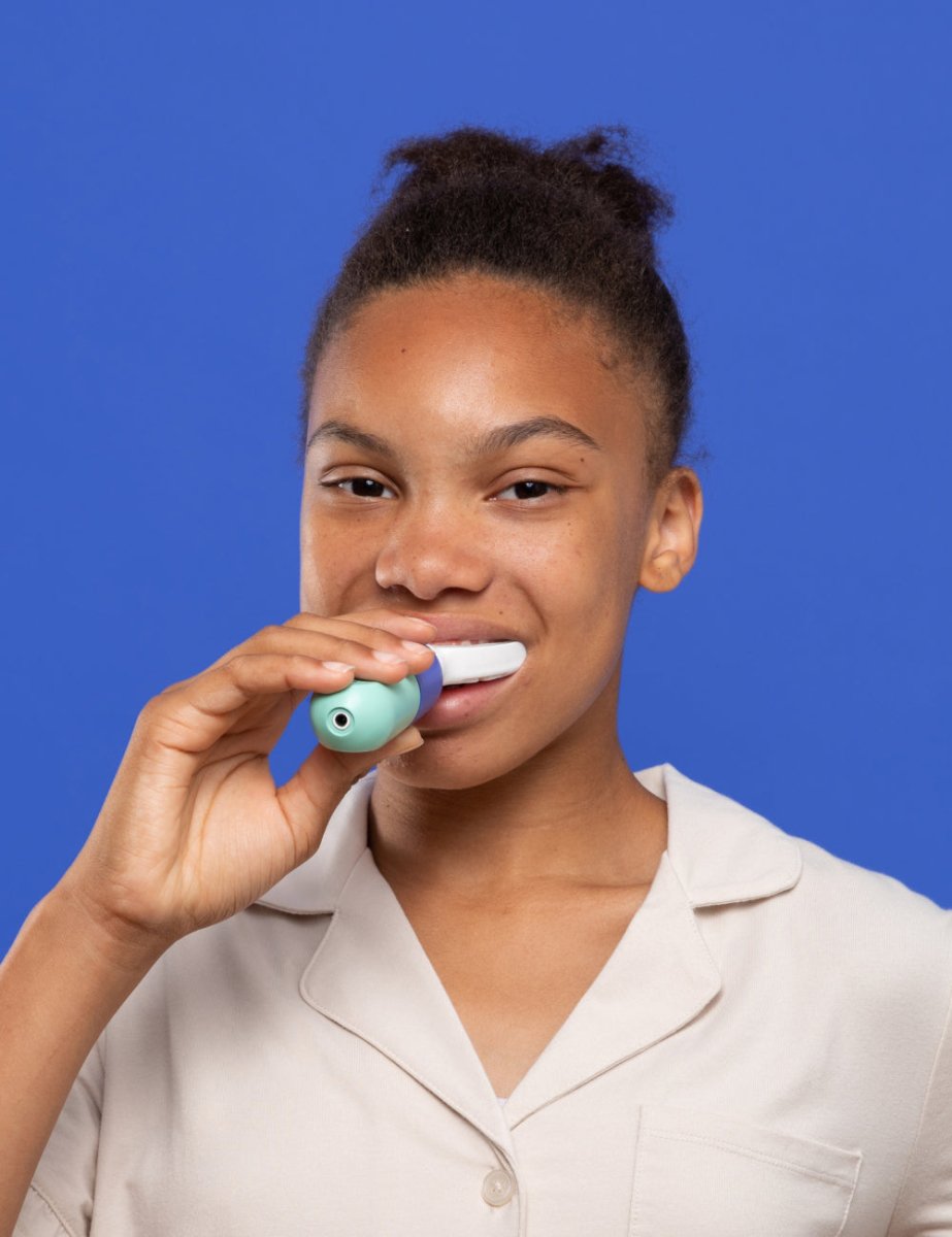 A girl cleaning her teeth with SymplBrush Jr. in a single 30 second guided cycle instead of a two minute manual routine.