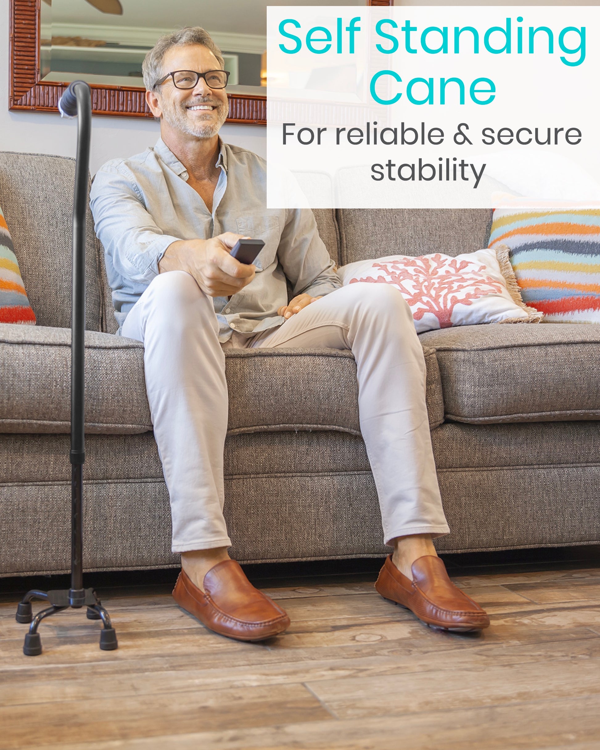 man sitting on couch with quad cane standing next to him