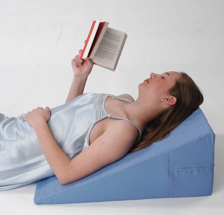 Woman reading lying on bed wedge